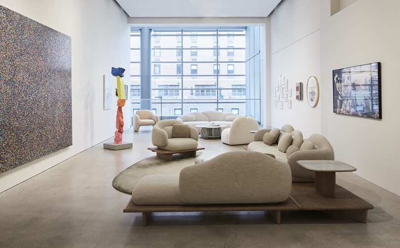 gallery space with overstuffed white furniture and a wall of windows