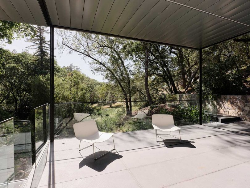 view out to elevated deck of modern house suspended over river
