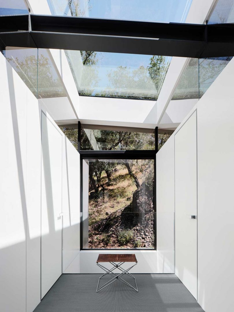 interior view of modern white closet with glass ceiling and window looking to rocky hill