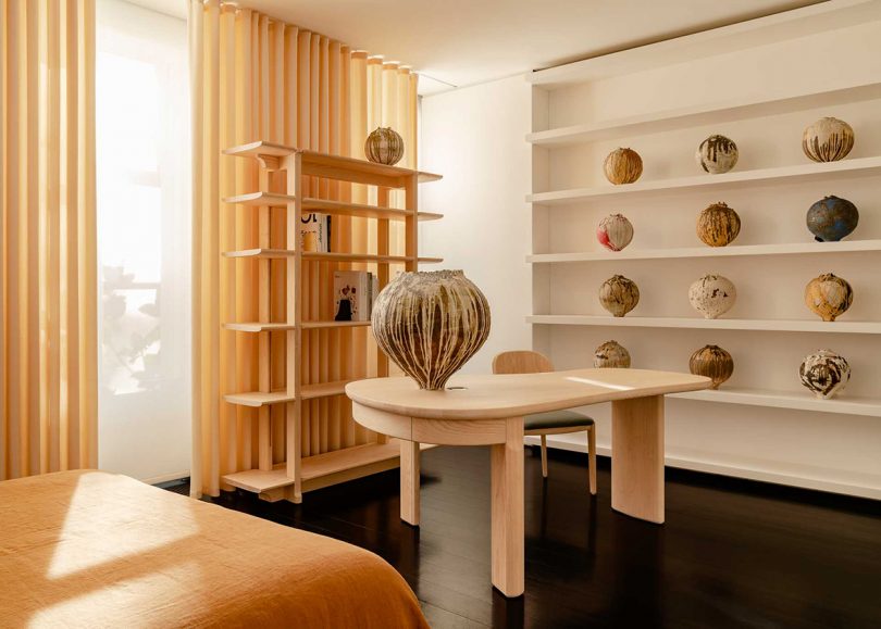 styled interior space with wood desk, chair, shelving, and decorative objects