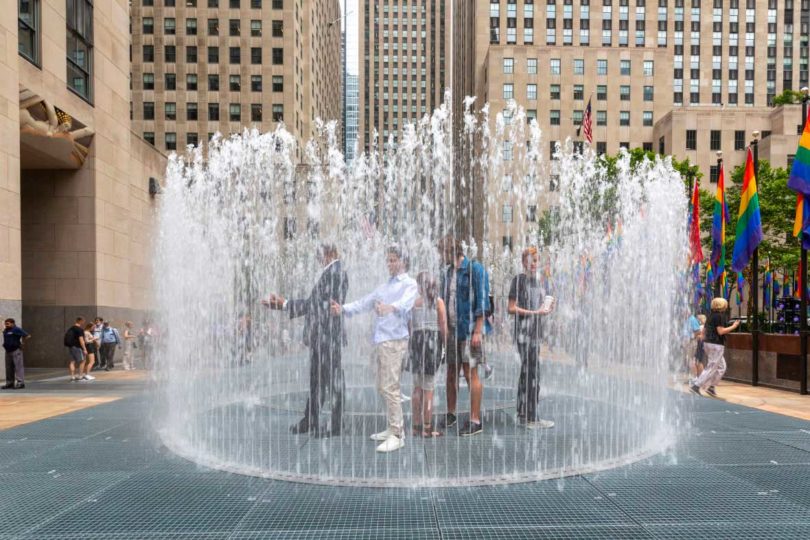 A group poses for cameras in the largest circle of water fountain exhibition