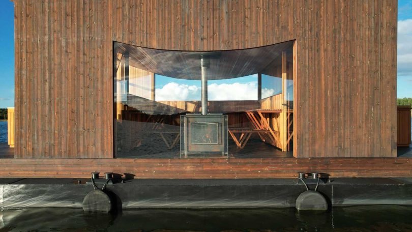 side view of modern wooden floating sauna on water