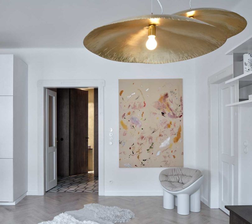interior view of modern apartment with muted painting and brass pendants
