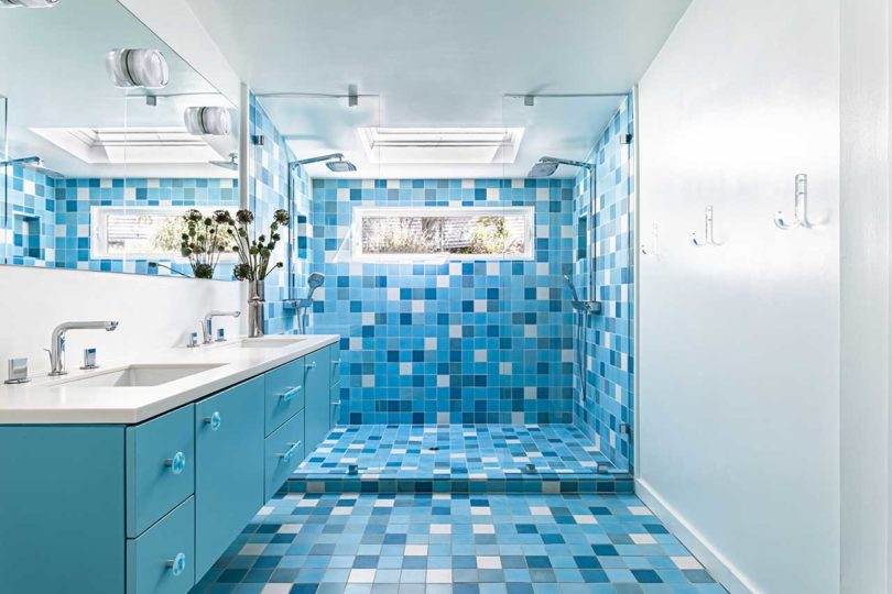 modern bathroom with blue cabinet and mosaic blue and white tiles