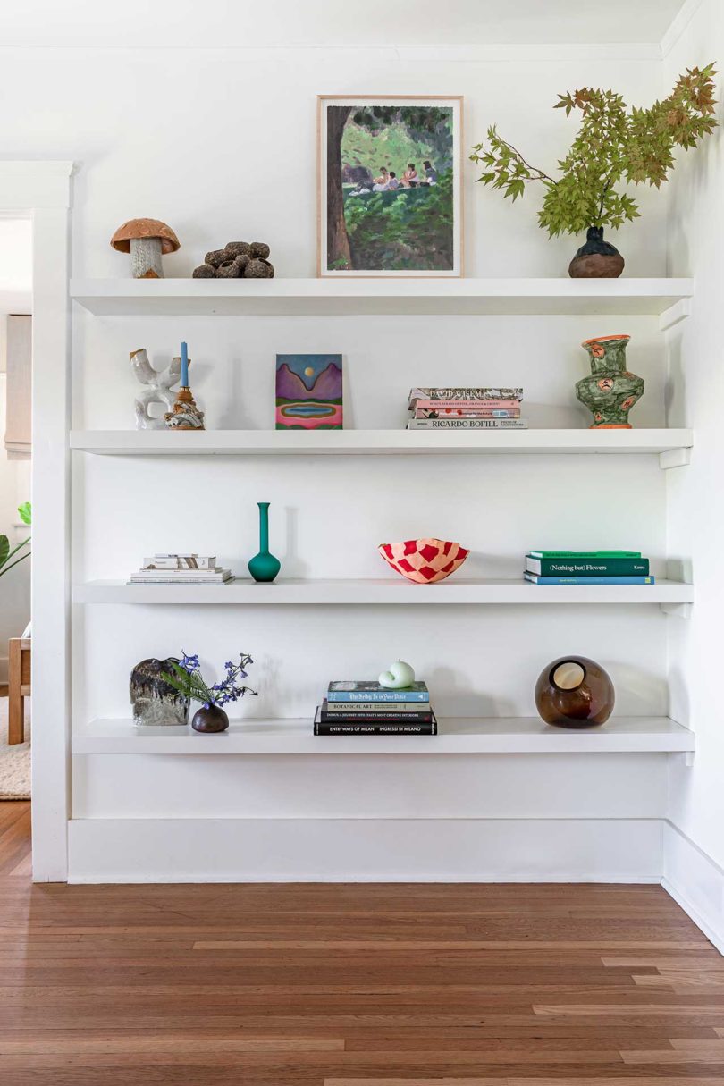 white wall with white shelves holding objects