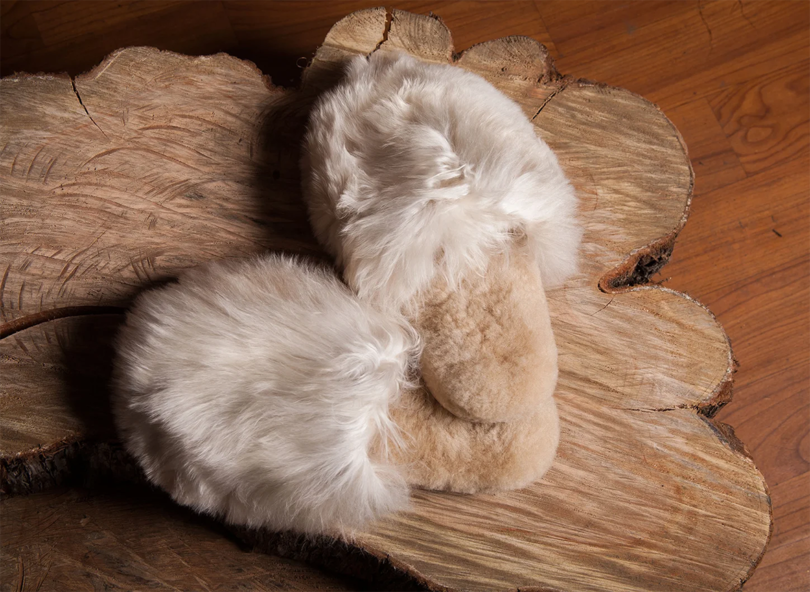 a pair of light beige alpaca fur slippers