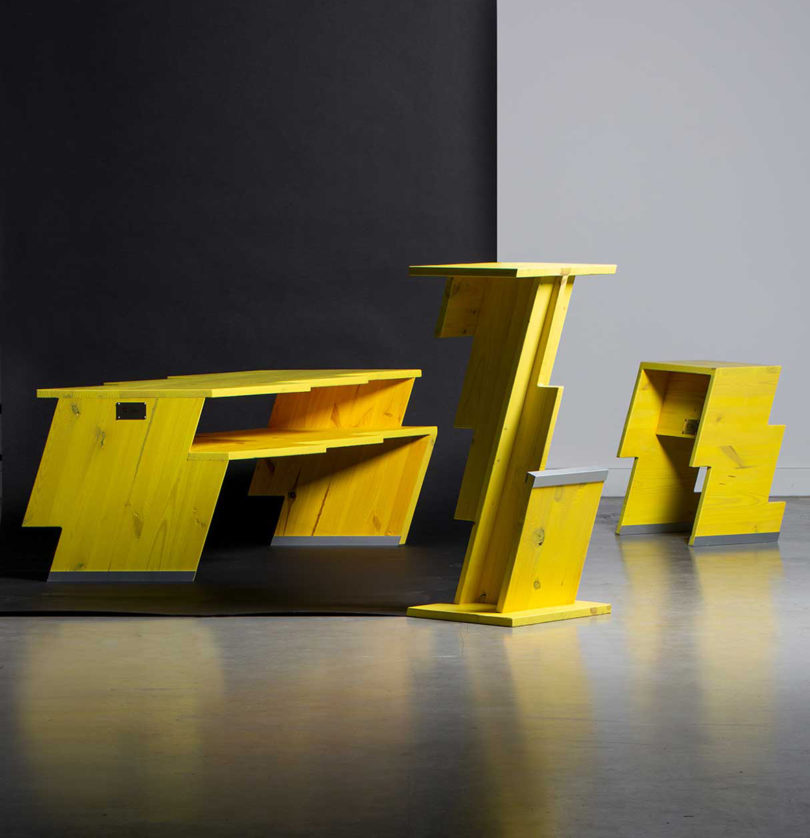 three yellow lightning bolt shaped pieces of furniture on black background