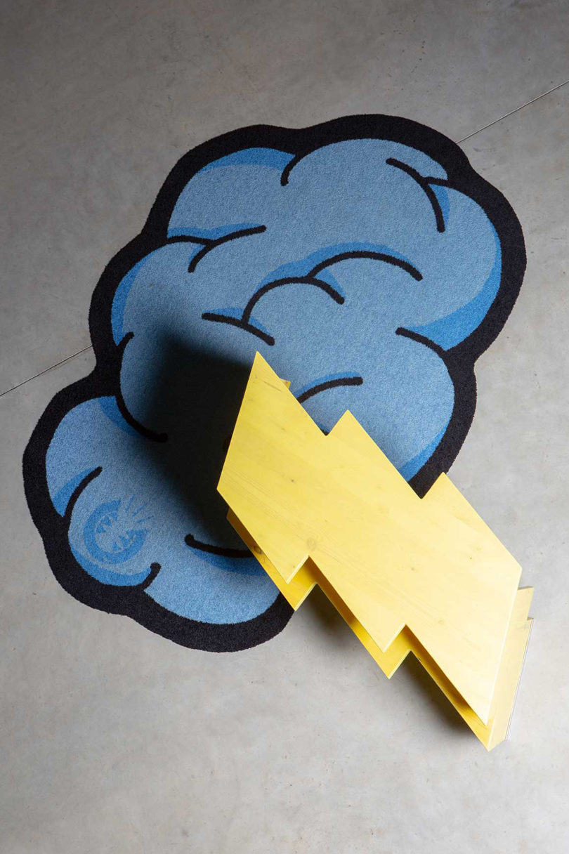 short yellow lightning bolt shaped table laying on its side on a blue illustrated cloud