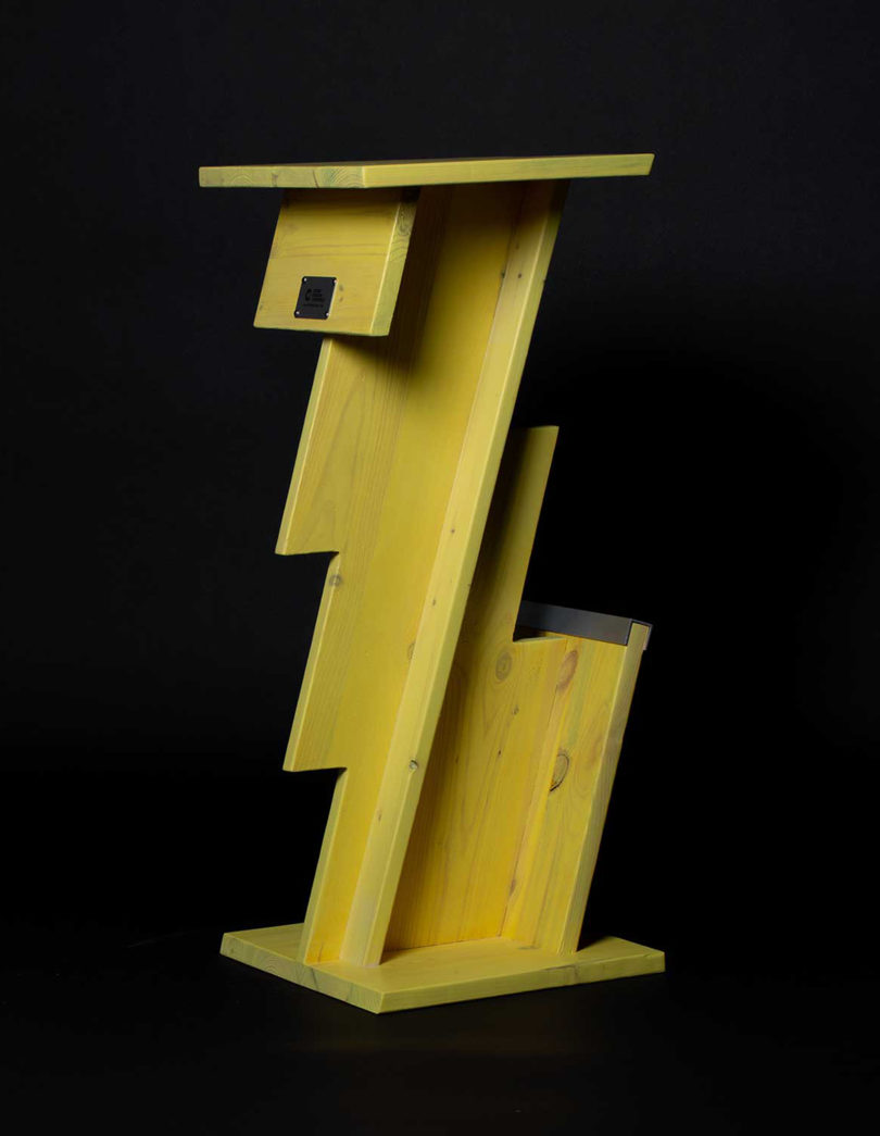 tall yellow lightning bolt shaped table on black background