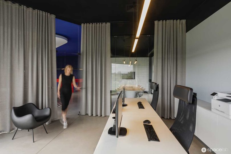 modern office interior with bold purple accents and gray curtains dividing space