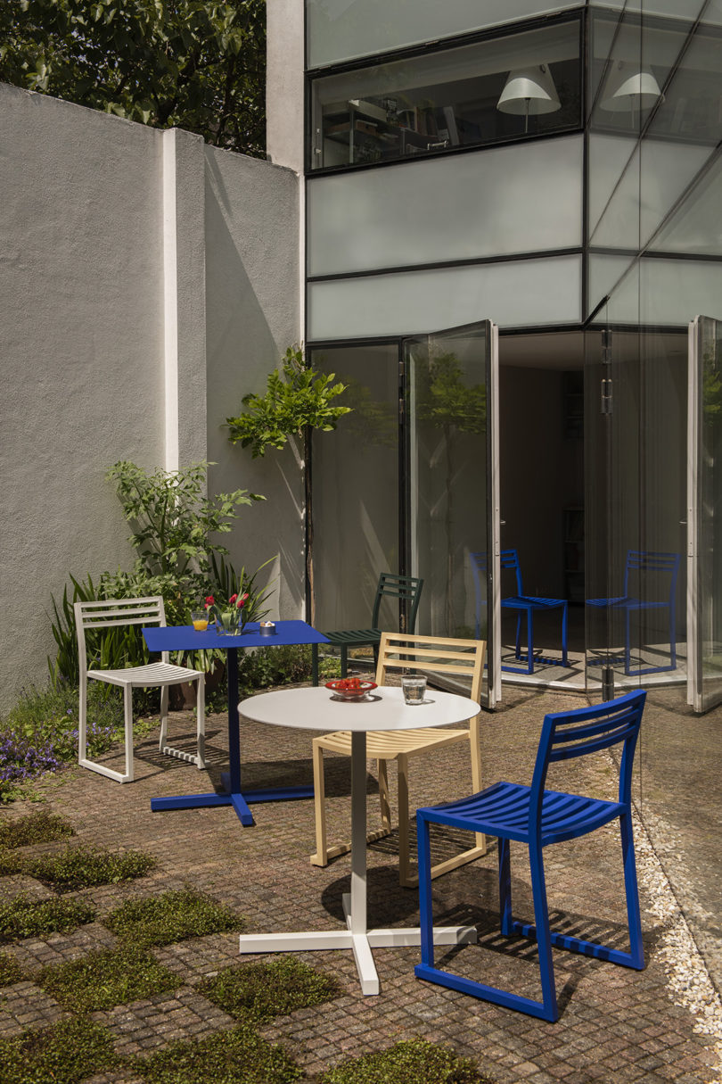 two styled electric blue and light grey cafe tables with four chairs outdoors