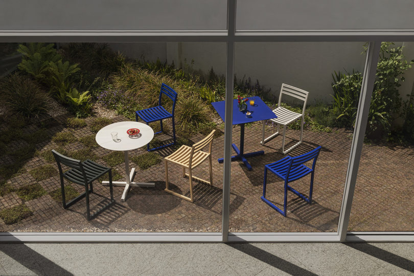 two styled electric blue and light grey cafe tables with five chairs outdoors