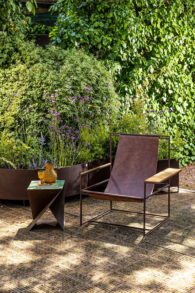 brown leather slingback armchair on an outdoor deck with a small side table