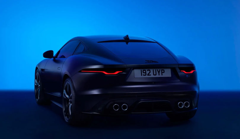 Angled rear view of Jaguar 75 Edition F-TYPE sports car against glowing blue background.