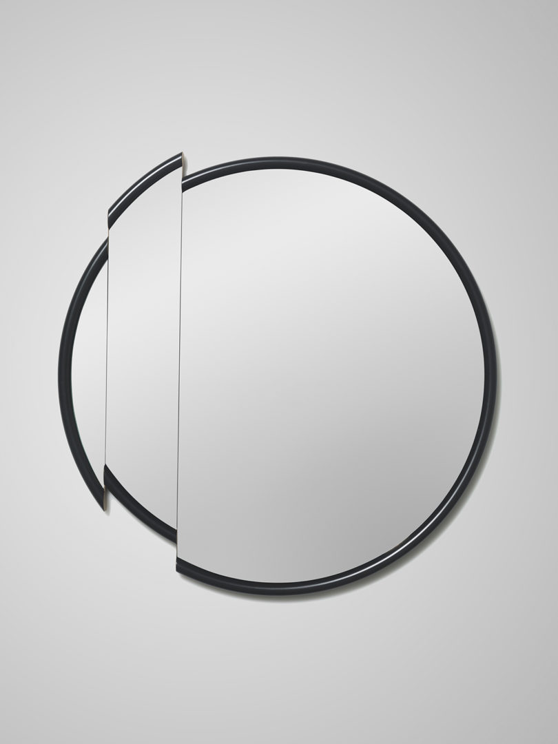 large round mirror with a black frame and slice taken out of it