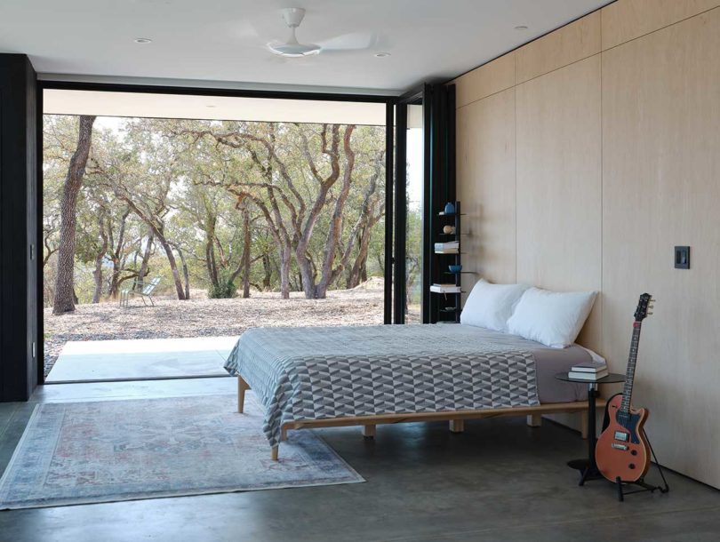 side view of modern bedroom open to outdoor landscape