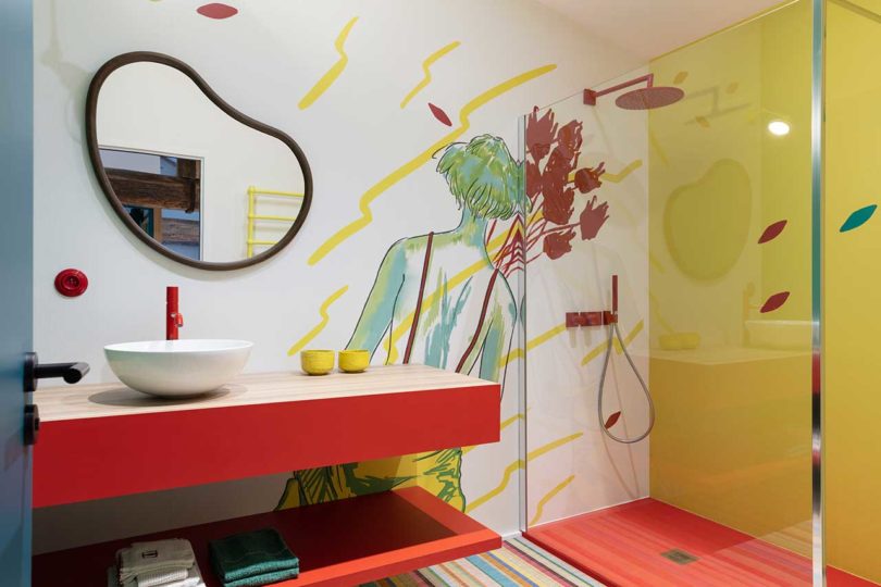 حمام مدرن با کنسول حمام قرمز و حوض دوش با دوش زرد با دیوار گلدار