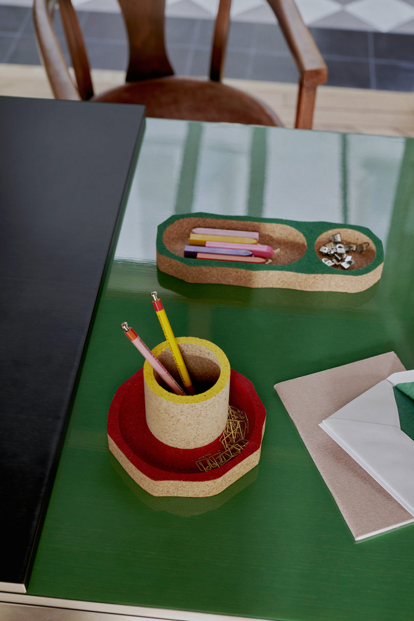 green lacquered desk with a corn pencil cip and cork tray