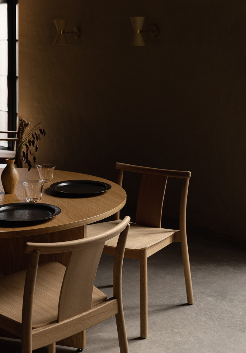 light oak dining chairs around a styled round dining table