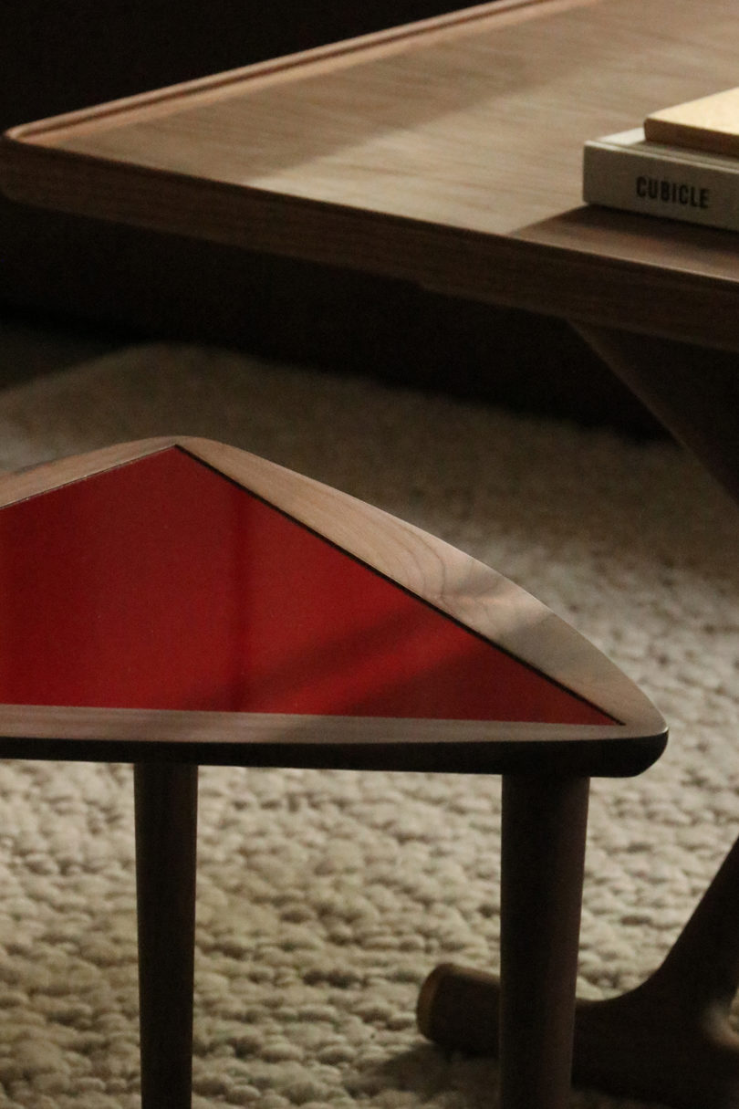 triangular wood and red laminate nesting table in a styled space