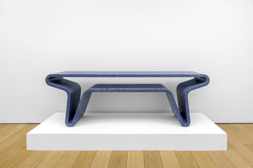 blue console table made from one continuous piece of material on white background