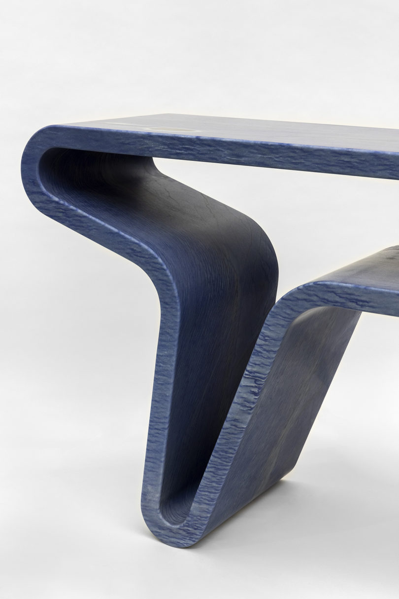 detail of blue console table made from one continuous piece of material on white background