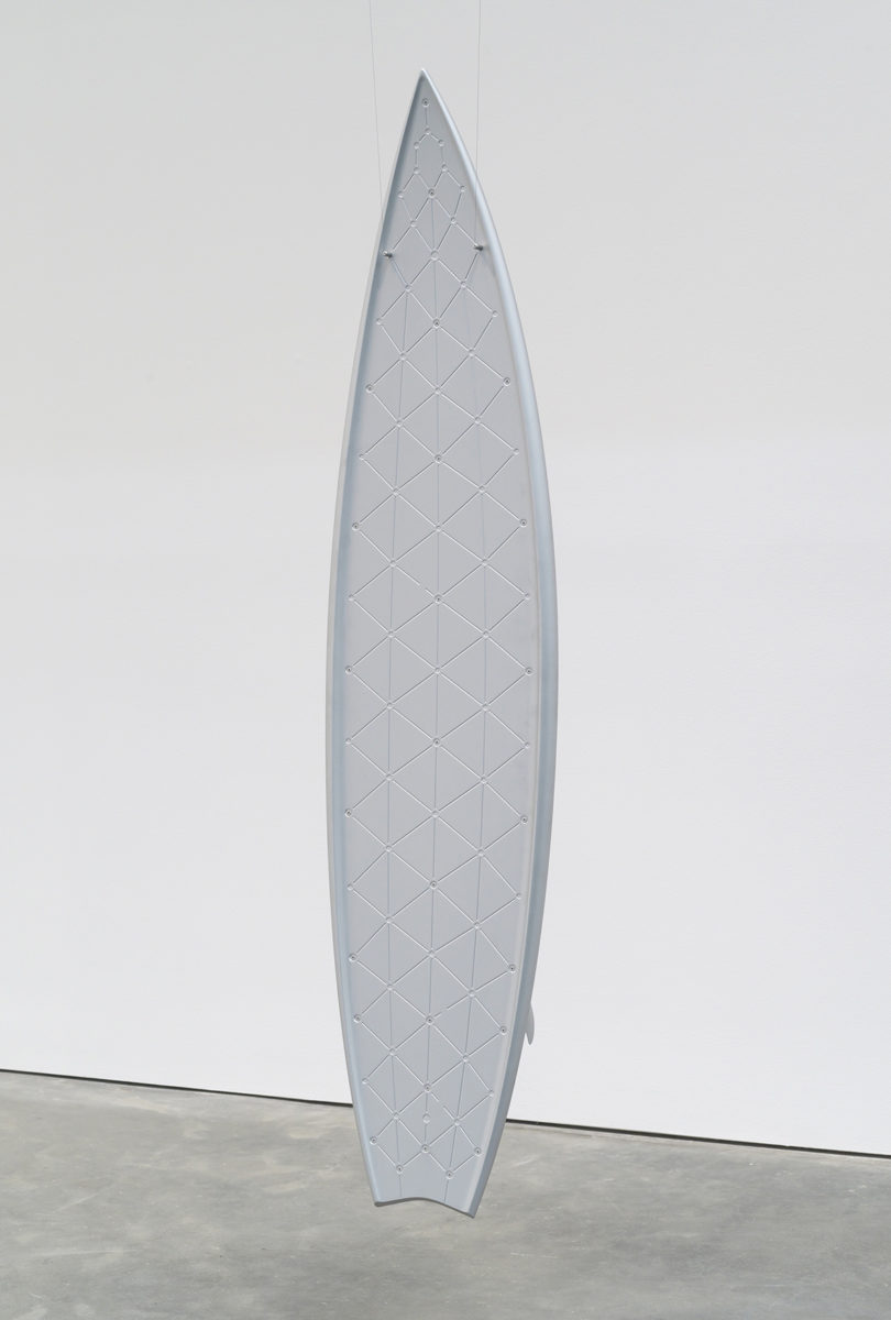 white surfboard leaning against a white wall