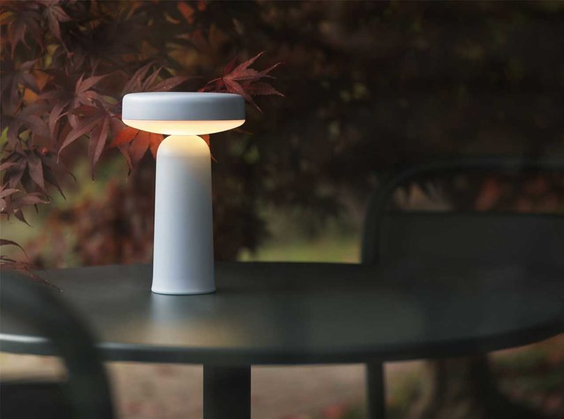 illuminated white modern table lamp on a round black table