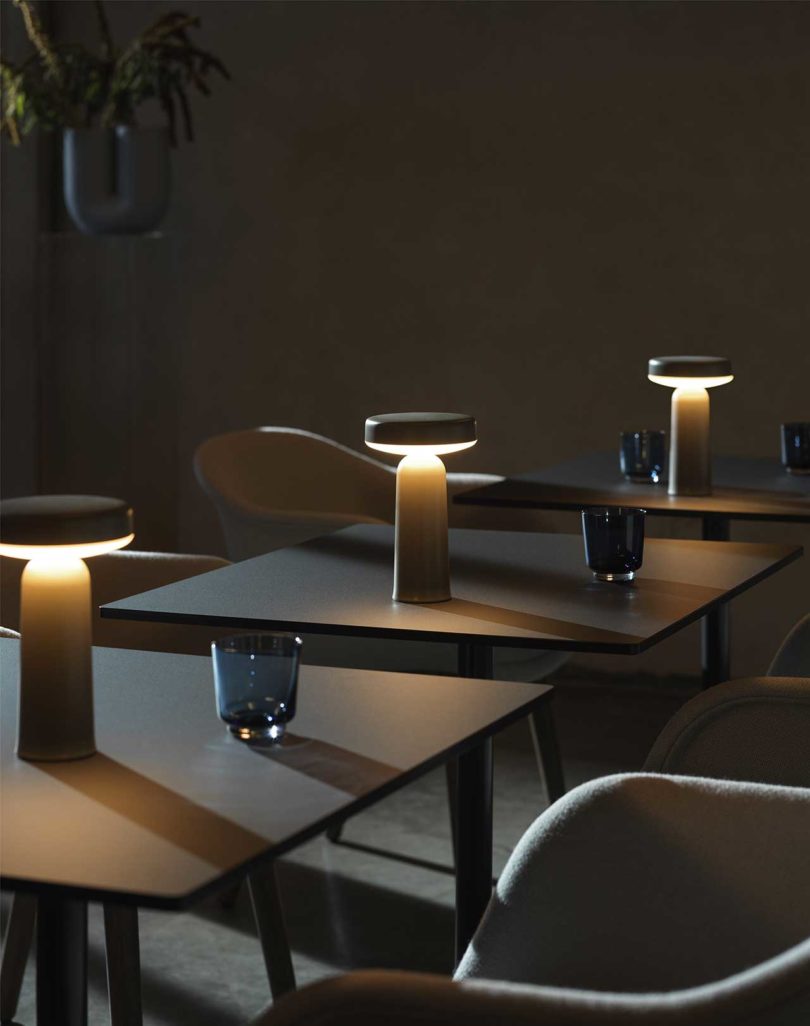 three illuminated modern table lamps on individual tables