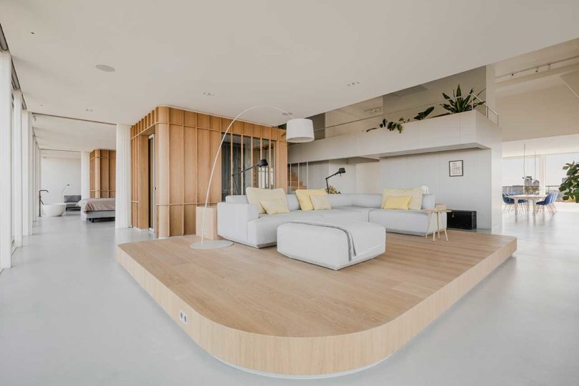 corner interior view of modern penthouse apartment with raised wooden platform for sofa