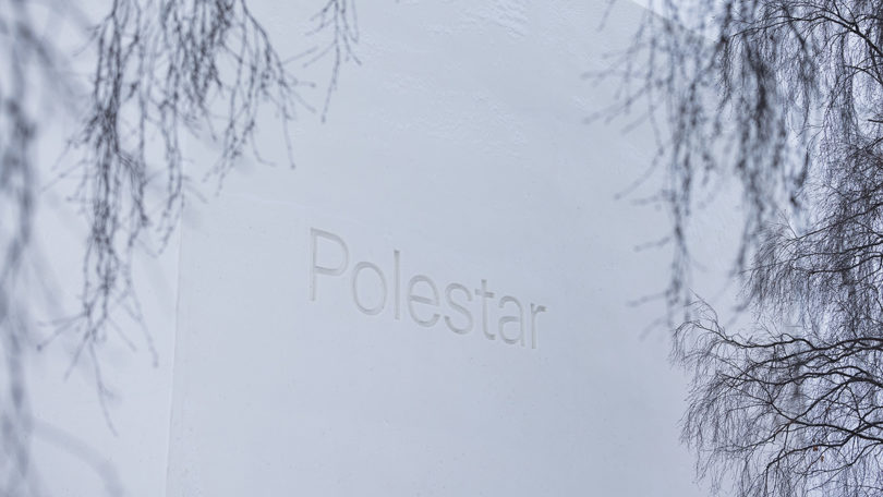 Polestar logo carved into snow/ice building facade.
