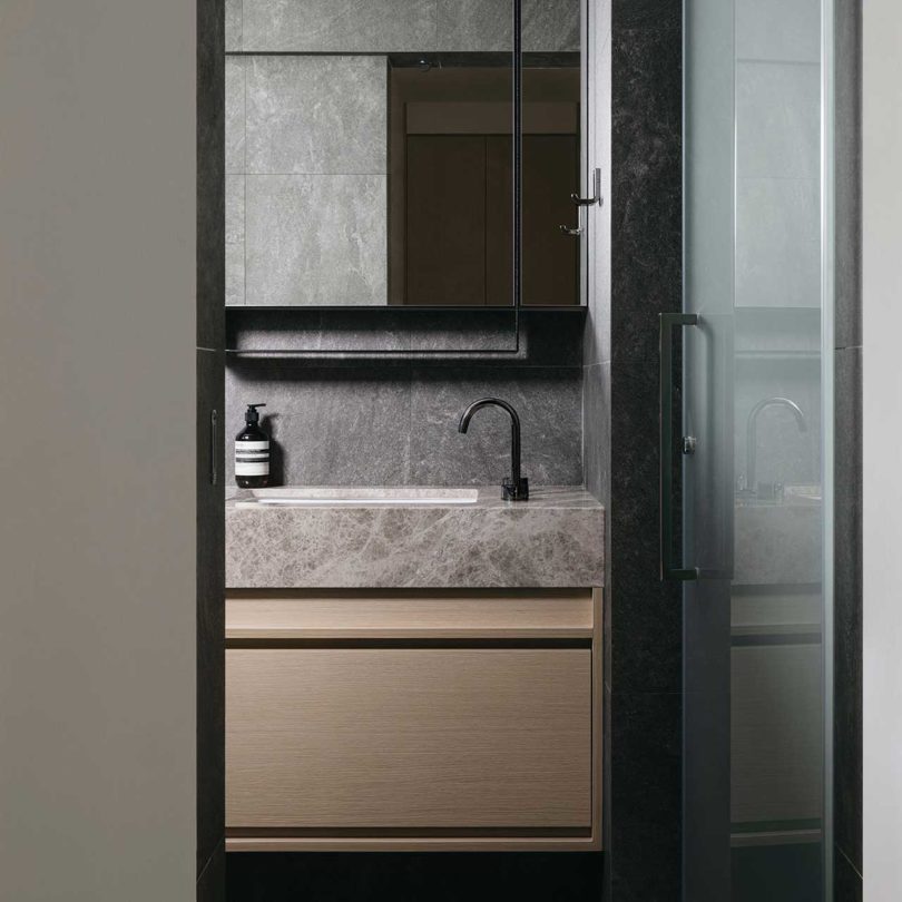 view into modern dark bathroom with gray tile