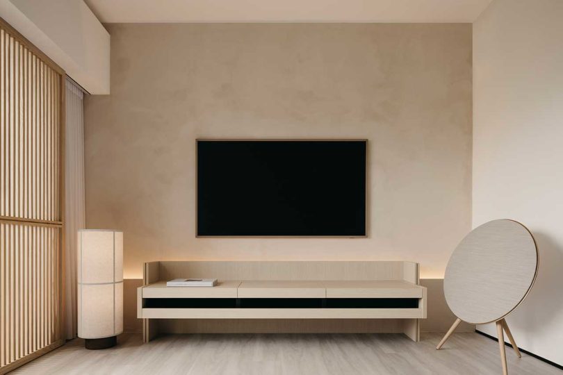 view in tv room of wood wall with mounted tv and simple low console