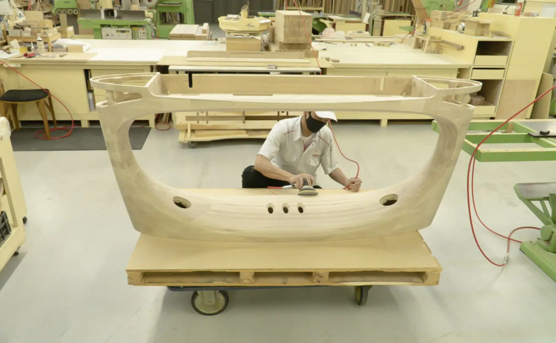 Craftsman sanding the body of the 50th Anniversary Concept Model Piano.
