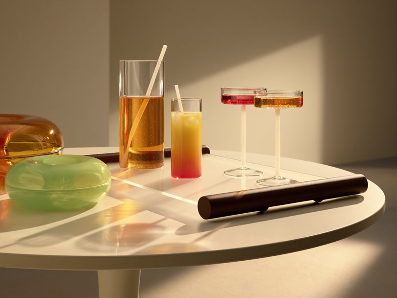 table styled with different types of filled glassware and a green donut-shaped object