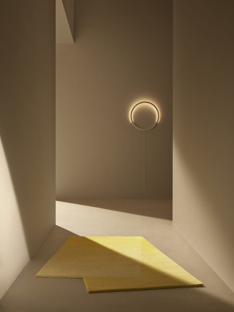 minimal modern interior with half circle wall sconce and yellow rug
