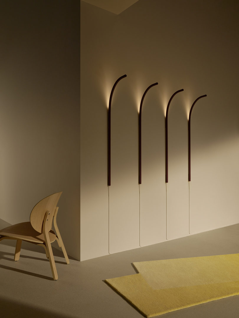 four ski-shaped wall lights, a wooden chair, and a yellow rug