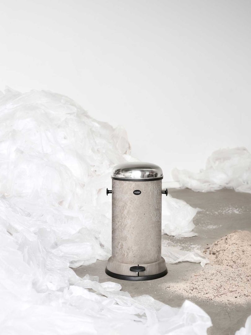 grey waste bin surrounded by raw materials