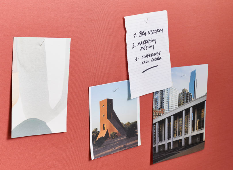 coral colored office wall with inspiration pinned to it