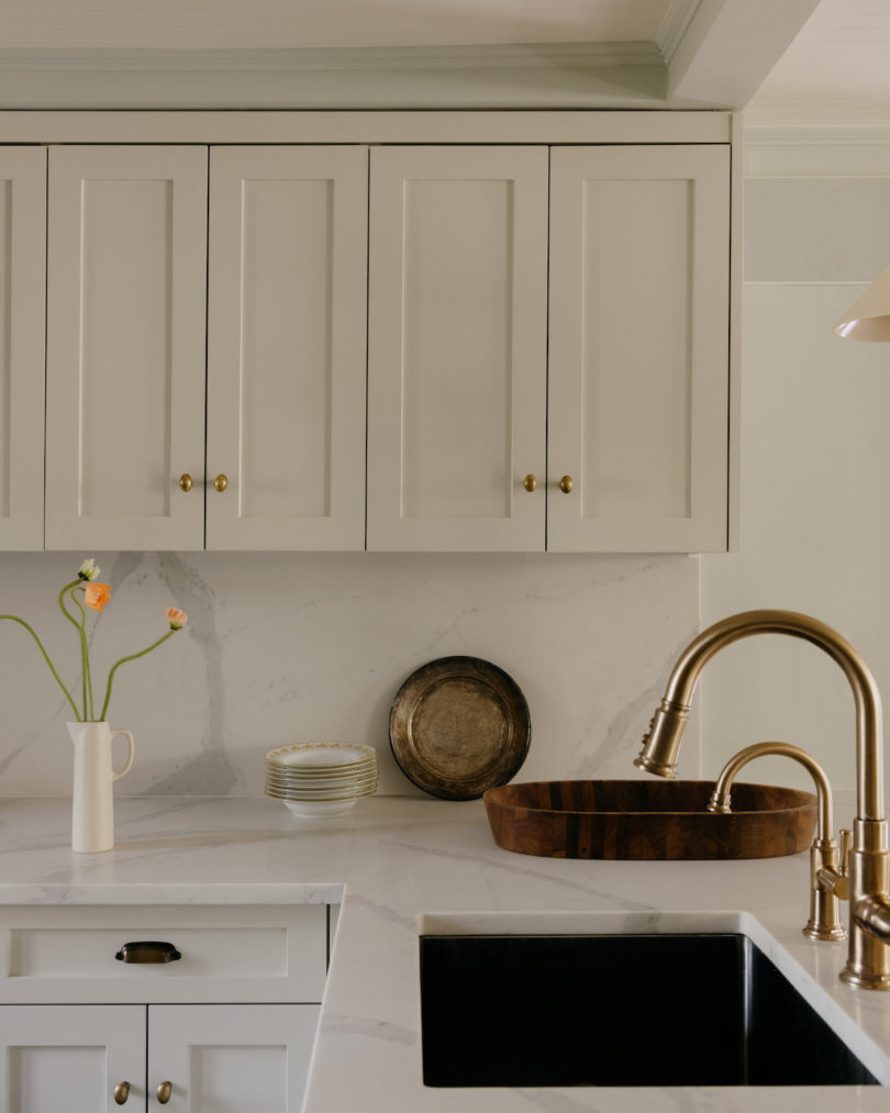 Antique opaline fixtures softly illuminate the kitchen, creating a cozy atmosphere.