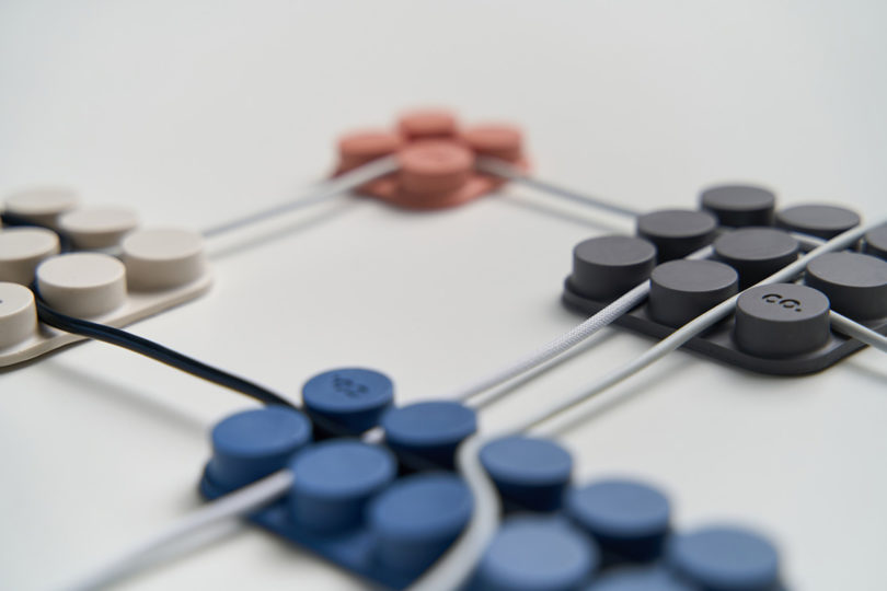 Angled view of four cord organizers with a white cable running through each.