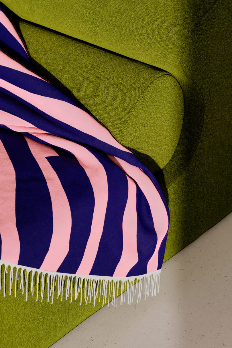 pink and blue throw blanket on green sofa