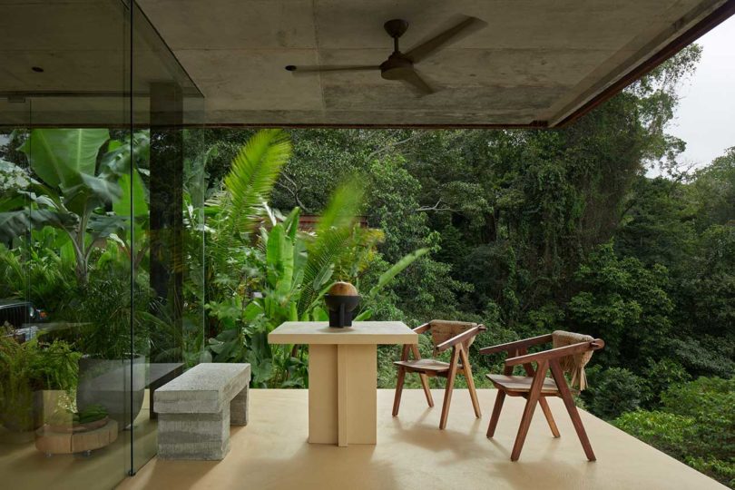 outdoor patio dining area with tropical plants behind