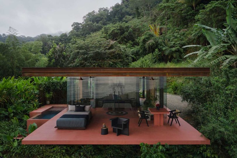 elevated view looking into cantilevered modern villa surrounded by tropical plants