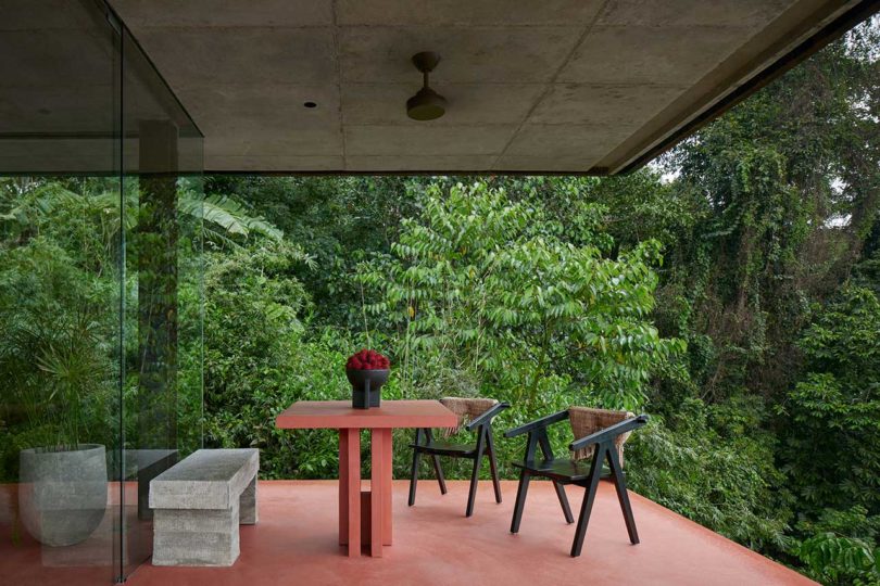patio dining set on red patio with tropical plants surrounding