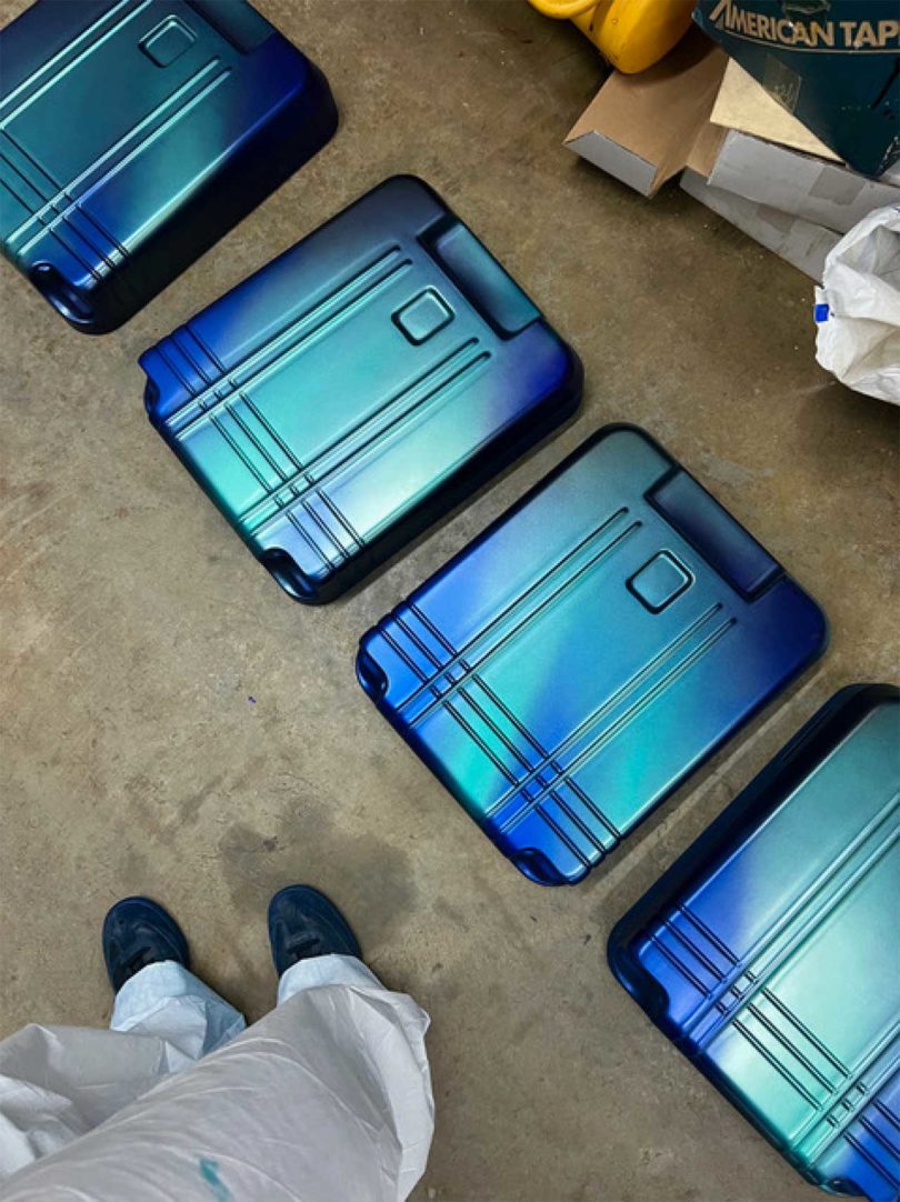 angled down view of four iridescent blue green suitcase shells
