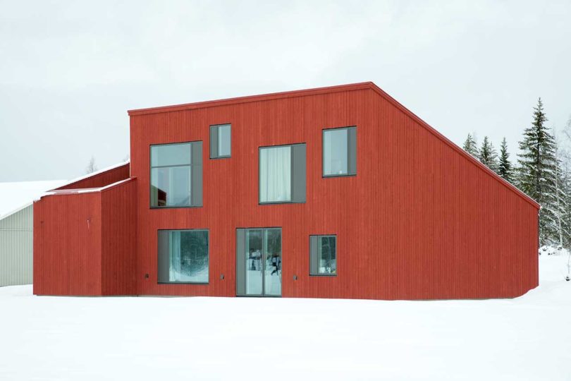 exterior view of modern red house in snow