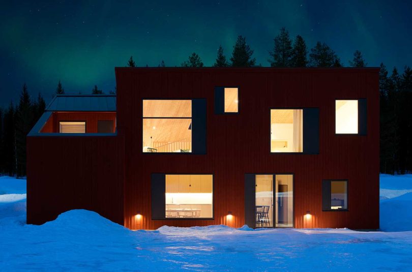 exterior view of modern red house in snow at night