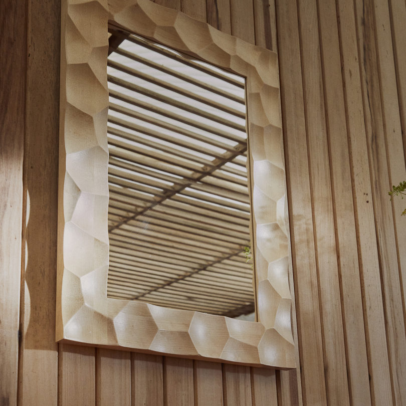 rectangular wall mirror with divotted frame hanging on a wall