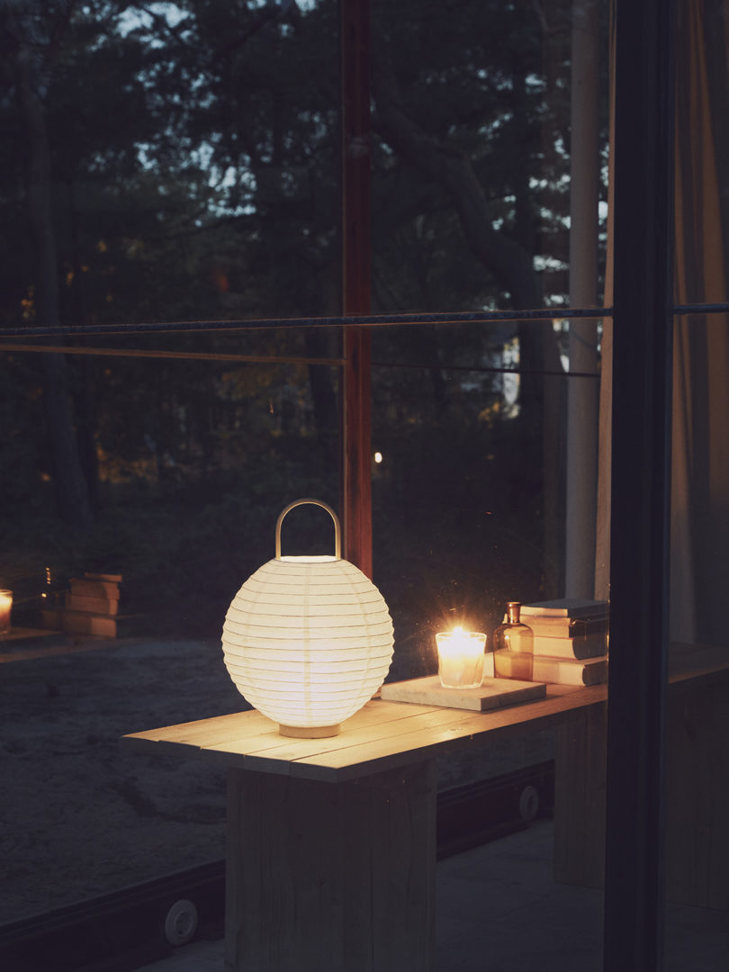 illuminated round paper lantern on a table in the dark